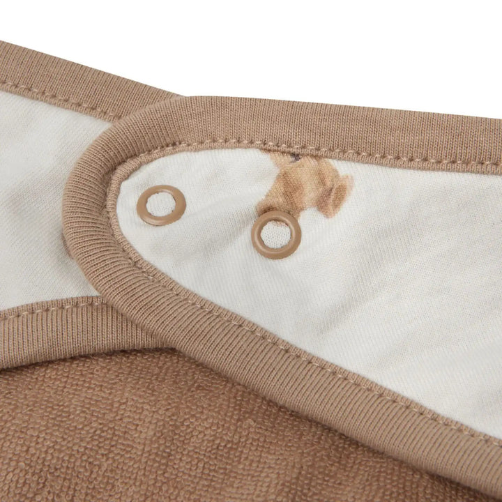 Detail van een zachte babycape in beige met drukknoopsluiting en katoenen voering
